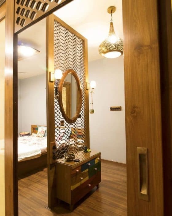 A-Dressing-Table-which-acts-as-a-Partition-Shows-Modularity-in-Design-with-Jali-Pattern-an-Oval-Mirror-with-the-Wooden-Frame Dressing Table