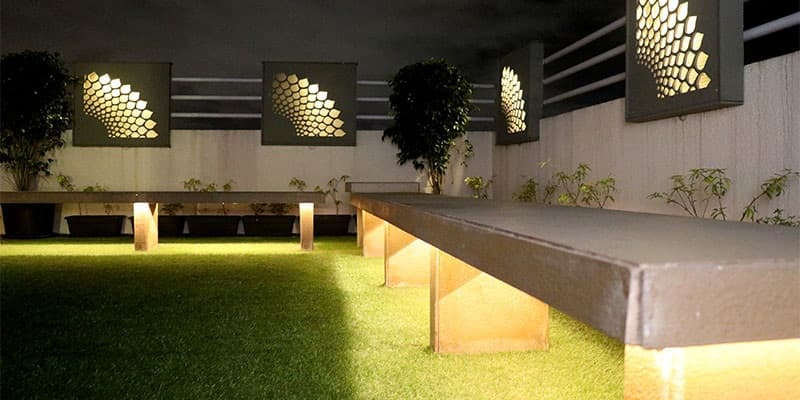 A-Lush-Green-Lawn-with-a-Stone-Finish-Fixed-Seatings-highlighted-by-Recessed-Lighting-1 Design Detail Banner 0