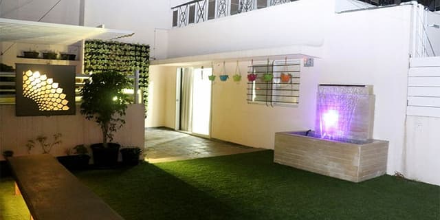 A-Lush-Green-Lawn-with-a-Stone-Finish-Fixed-Seatings-highlighted-by-Recessed-Lighting-2 Swiper Content 1