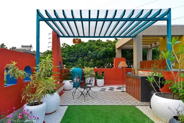 Home-Garden-on-Terrace-Floor-having-Parapet-Wall-with-Red-Wall-Paint-having-Voids-with-Blue-Wall-Paint-2 Swiper Content 1