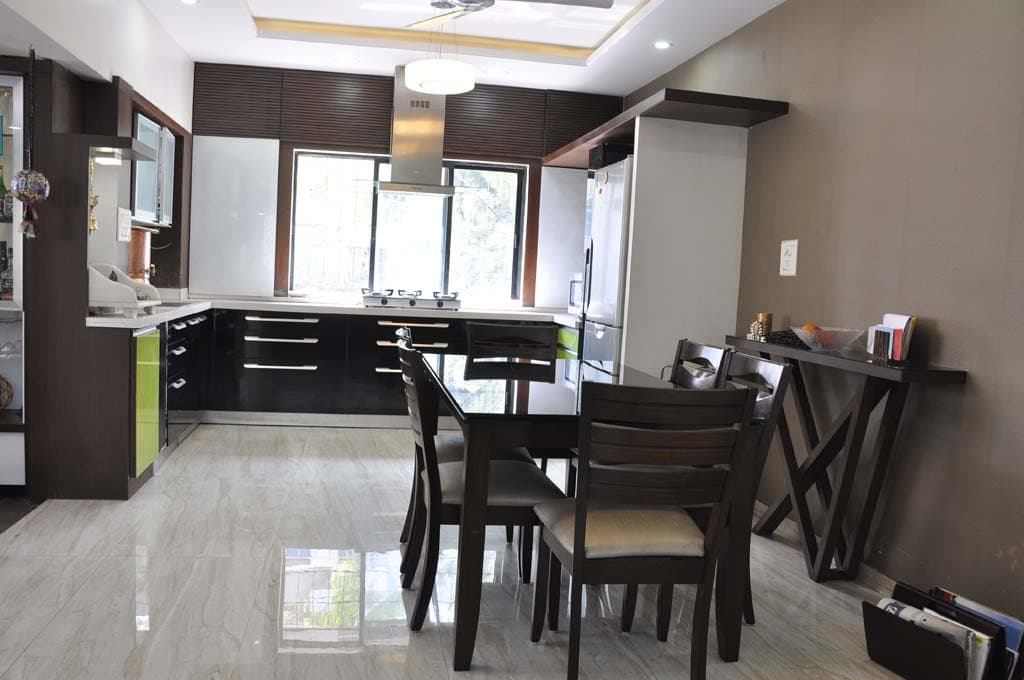 A modern dining area is placed on the side of an open-plan kitchen A modern dining area is placed on the side of an open-plan kitchen