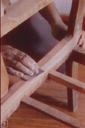 Scrape wooden frame with sandpaper