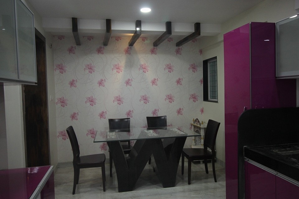 4 – Seater Wooden Dining Table with Glass Top, Textured Wallpaper highlighted by Recessed Lighting & POP False Ceiling