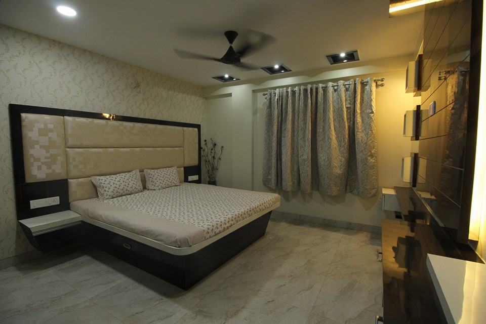 Bedroom designed with Wooden Bed, Side Tables attached with High Cushioned Headboard