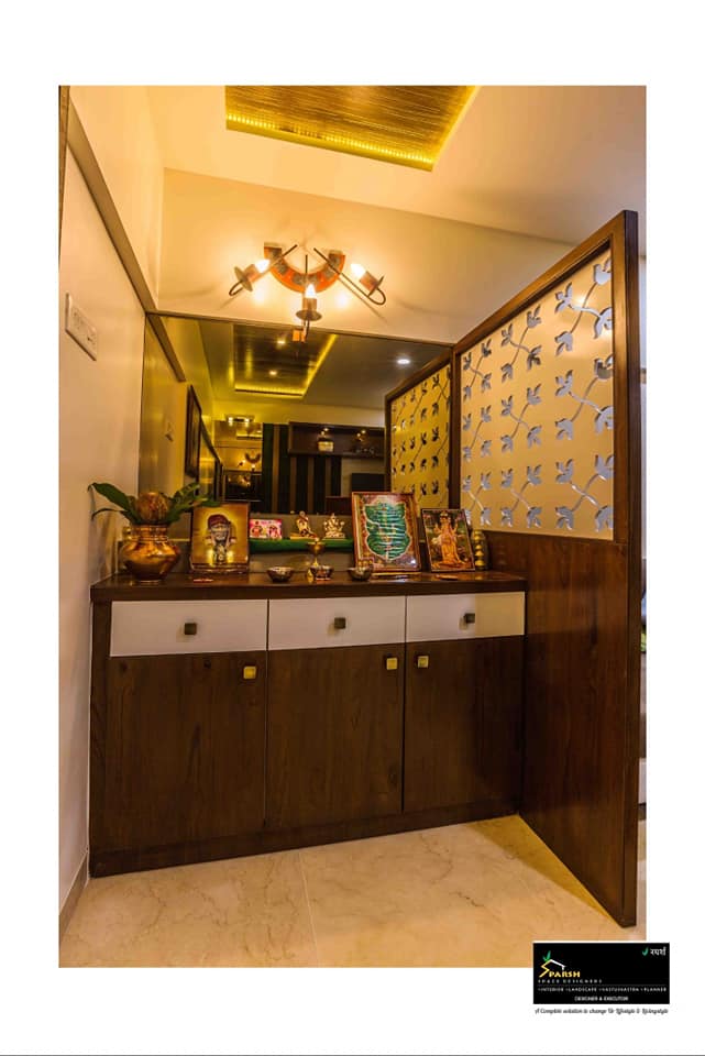 Pooja area with a wooden platform under which there are white drawers