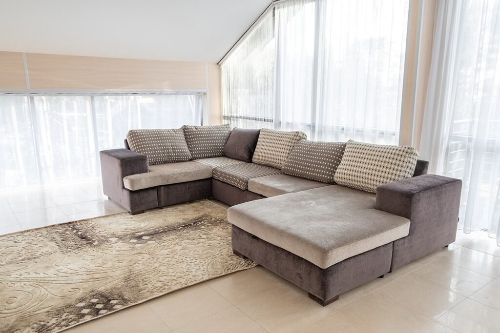 A C-shaped grey sofa in a white