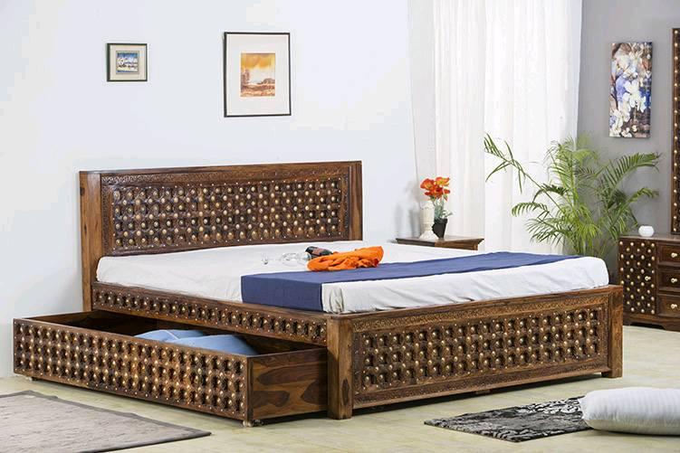 An intricately designed dark wooden bed