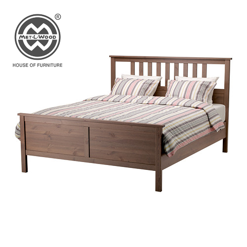 Dark wooden bed with slender legs on all four sides