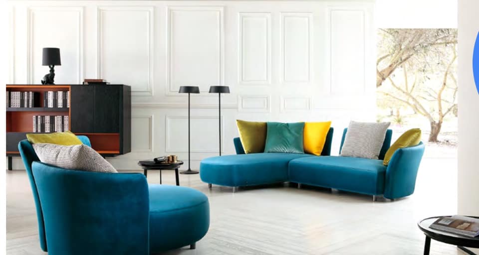 A Blue Upholstered Sofa having Beautiful Curves is Making Good Contrast with the Colourful Cushions