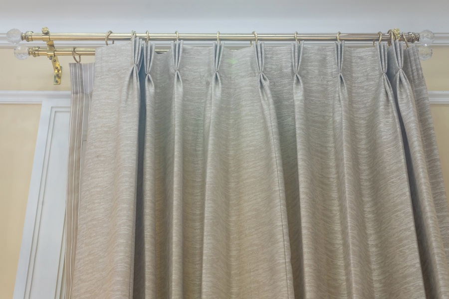 Grey curtain hanging from curtain poles Grey curtain hanging from curtain poles