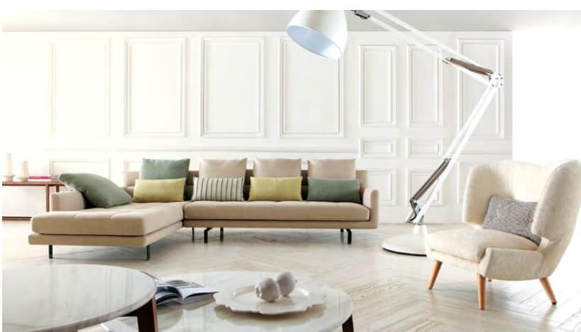 The Beige Upholstered Sectional Sofa is Nicely Place with this Wingback Upholstered Chair having Wooden legs