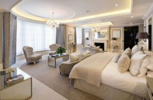Luxury bedroom design with cream and silver tones and tufted armchairs