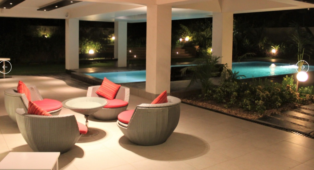Modern rounded wicker chair with soft red cushions